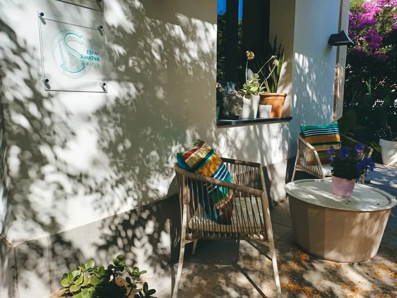 Entrada de l'Espai Samatva amb plantes i cadires de vímet